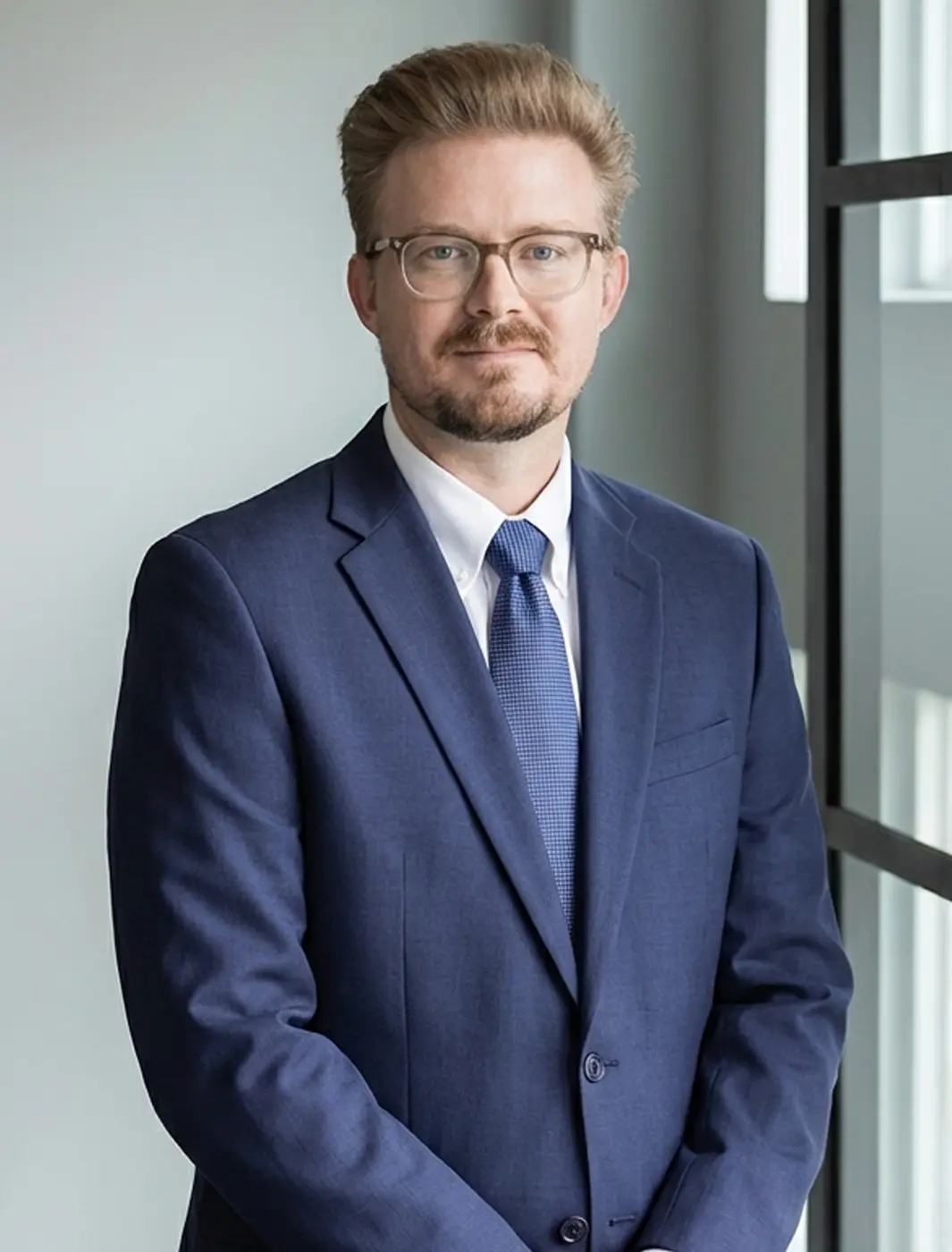 El abogado litigante especializado en lesiones personales Brady Williams, vestido con toga, frente a la sala del tribunal antes de que comience un juicio por litigio médico.