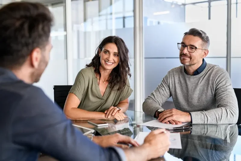 A family sits at a table with a medical malpractice lawyer, discussing litigation and resolution to their injury claims.